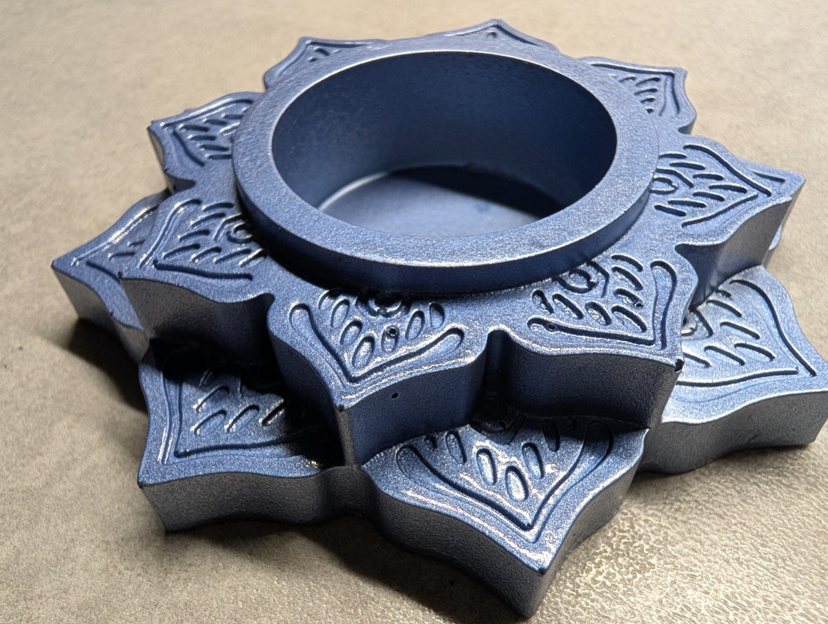 Angled view of the Metallic Blue Jesmonite mandala tealight holder, showing the raised floral layers and depth of the central recess.