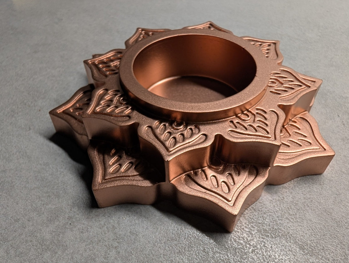 Angled view of the Copper Jesmonite mandala tealight holder, showing the raised floral layers and depth of the central recess.